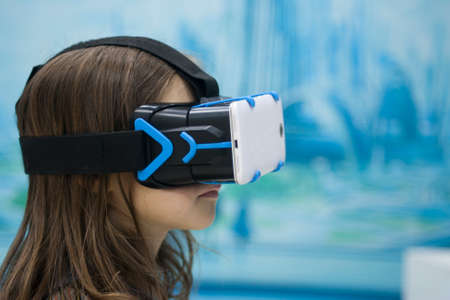A child in virtual reality glasses makes a walk with dinosaurs