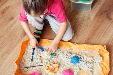 The child forms various forms of sand at home