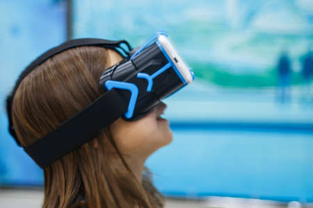A child in virtual reality glasses makes a walk with dinosaurs