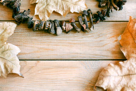 Autumn still life with dry maple leaves on wooden table with free space for textの写真素材