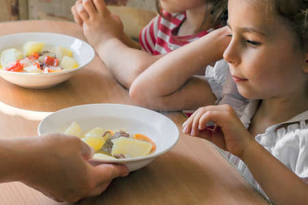 grand daughters have dinner with their grandmotherの写真素材