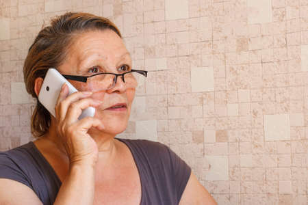 An elderly lady talking on a mobile phoneの写真素材