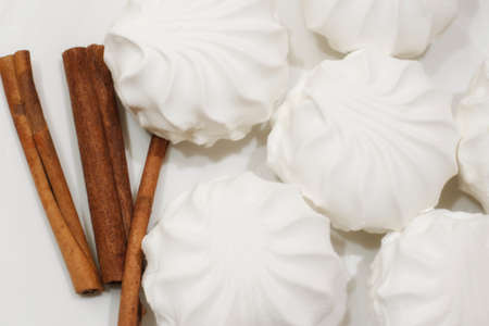 White airy marshmallows with sticks of fragrant cinnamonの写真素材