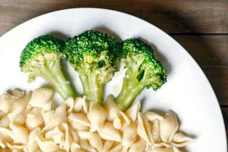 cabbage broccoli with pasta on a white plateの写真素材