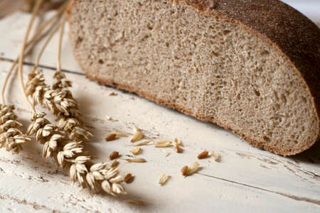 Rye bread and ears of wheat on a wooden table. Rustic Still Life