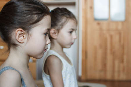 Two little girls are keenly watching a cartoon