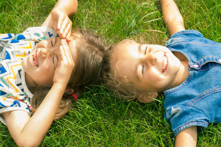 Girls to lie on the green lawn under the summer sunの写真素材