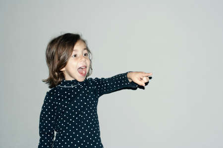 Little girl emotionally pointing at something interestingの写真素材