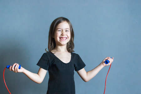 Happy healthy girl plays with a rope. A healthy lifestyle from childhood