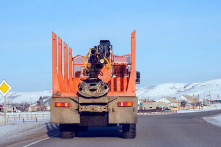 Orange timber transport goes on a country roadの写真素材