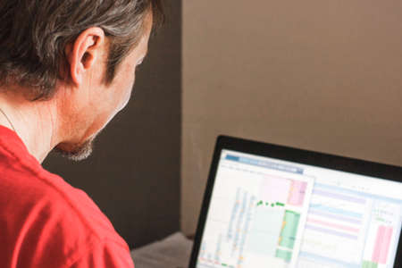 A man sitting at a computer and working on the stock exchange