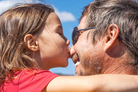 Little girl kisses her dad in the noseの写真素材
