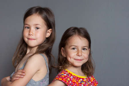 Two beautiful girls-models of preschool age with lovely smiles