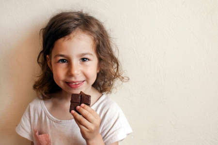 A child in anticipation of a sweet dessert. Chocolate in hand, gourmet smileの写真素材