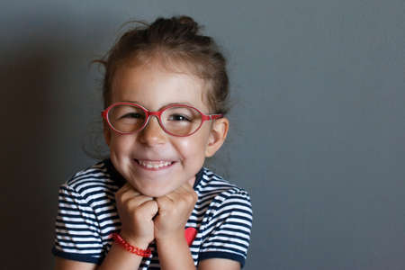 The little girl first put on corrective glasses and saw the world around her in the smallest detailの写真素材