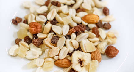 Mix of nuts and dried fruits on a white plate