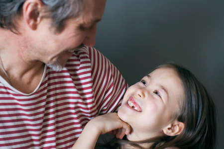 The look of a happy loving girl to her grandfatherの写真素材