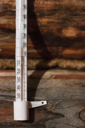 Street thermometer on the wall of a wooden houseの写真素材