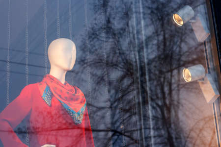 Female mannequin in a red dress through a storefrontの写真素材
