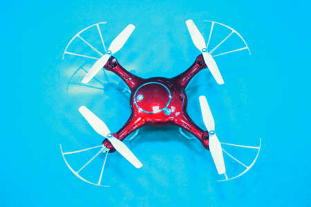 red kuadropopter on a blue background. Flying drone with cameraの写真素材