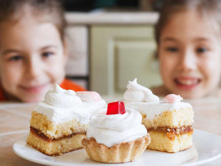 Two small hunters for sweets want to steal a cake from the tableの写真素材