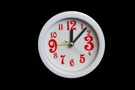 White alarm clock with red numbers isolated on a black background