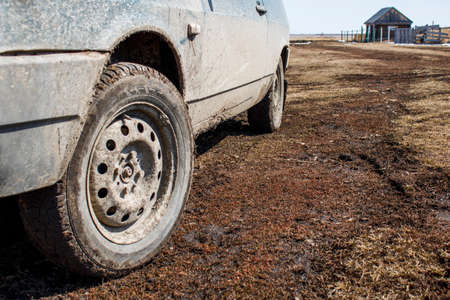 A dirty car on a rural road close up