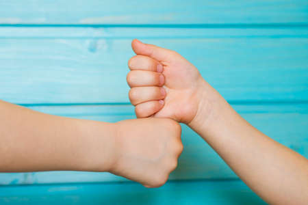 Children's hands clenched into fists. Cheerful greeting