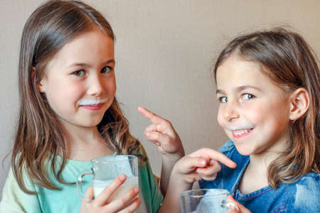 two funny little girls with white mustache from milkの写真素材