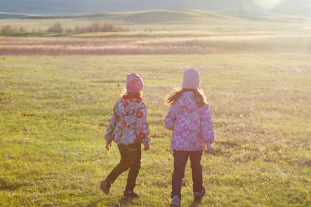 Children are walking in nature. Mountains, fields in the morning sunの写真素材