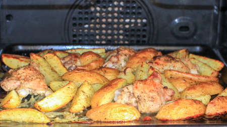 Fried potatoes with chicken with golden crust in the ovenの写真素材