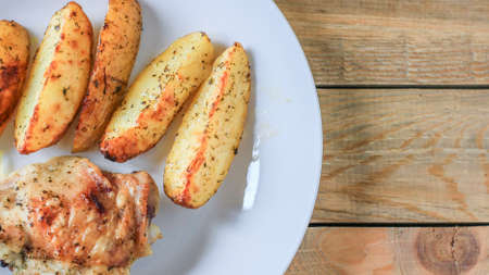 Fried potatoes with chicken with golden crust on a white plate