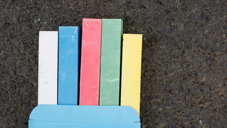 Multi-colored children's crayons on a dark asphaltの写真素材