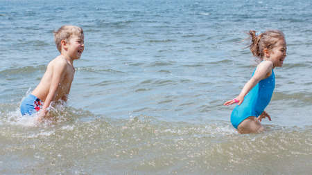 Children have fun playing on the seashoreの写真素材