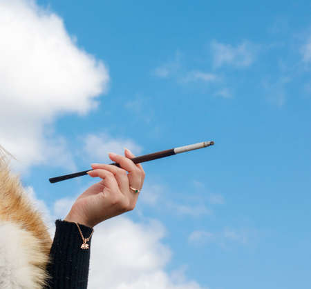 Hand of a young girl with a mouthpiece against the blue skyの写真素材