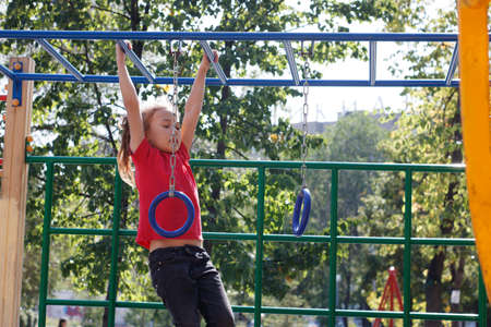 A girl climbs the stairs on the playground in the park