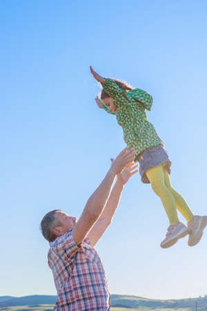 Happy dad walks with his daughter in the summer parkの写真素材