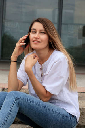 Girl in a white shirt on the steps of the university. The applicant is preparing for the school...