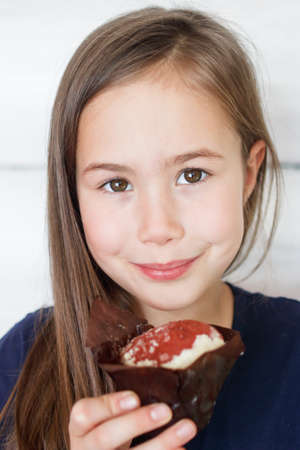 Portrait of a smiling girl with a beautiful cupcakeの写真素材
