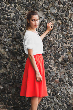 Beautiful girl in a fashionable bright red skirtの写真素材