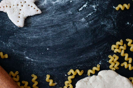 Dough, rolling pin, flour and pasta on the black table.の写真素材