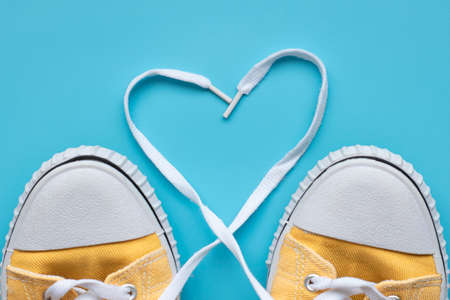 Yellow summer youth sneakers on a blue background with copy spaceの写真素材