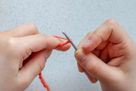Child girl takes the first steps in learning crochet
