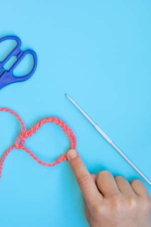 Step-by-step instructions for children how to crochet a bracelet from yarnの写真素材