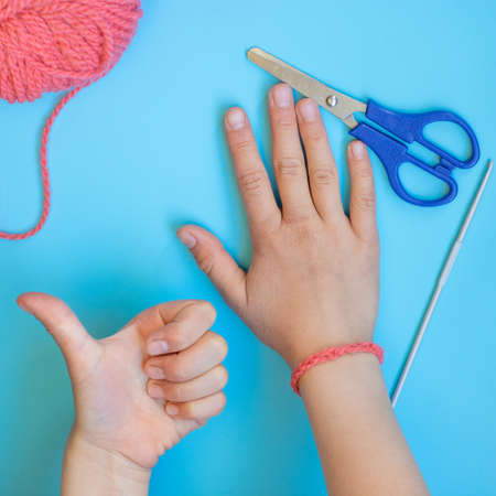 Step-by-step instructions for children how to crochet a bracelet from yarnの写真素材