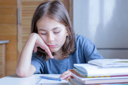 The child fell asleep from boredom while doing homeworkの写真素材