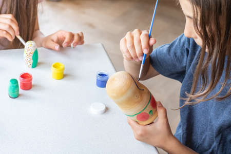 A child paints a wooden blank of a nesting doll. Children's craftsの写真素材
