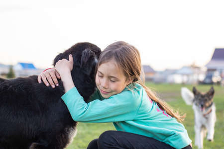 Girl gently hugs her beloved big dog.