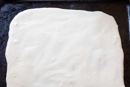 Dough for homemade pizza on a baking sheetの写真素材