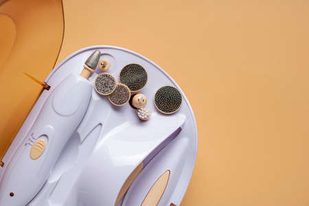 Set for home manicure with various nozzles on a beige background. Banner Template with copy spaceの写真素材